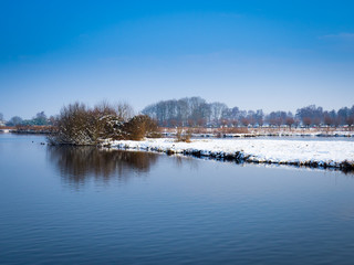 Snow landscape with trees and frozen trenches in Gouda Netherlands