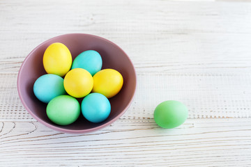 Colored eggs in a plate. The concept of Easter and spring.