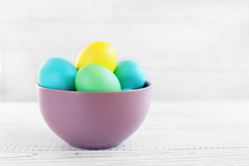 Colored eggs in a bowl. The concept of Easter and spring.
