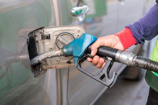 Hand holding a blue fuel pump, refuelling a passenger car.
Blue Fuel nozzle fill the gas tank at gas staion.