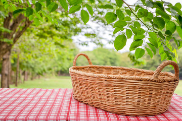 Fototapeta na wymiar Empty wicker basket on the table with the natural background.