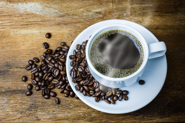 Coffee cup and coffee bean on a wooden table