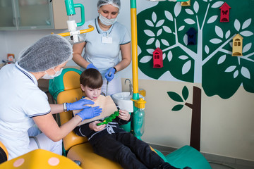 dentist and nurse curing childe teeth