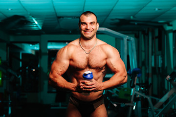 Fototapeta na wymiar Handsome man with big muscles, posing at the camera in the gym