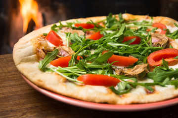 Pizza vegetariana con carciofi, rucola, pomodoro e mozzarella