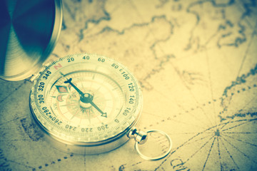 Old  gold vintage compass on vintage map:Heading south ;vintage tone style