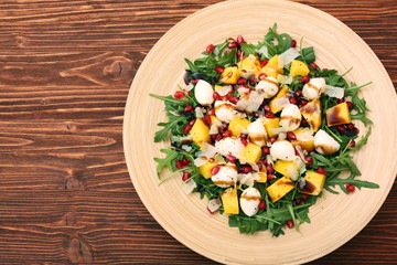 Salad with arugula, mango, cheese and pomegranate