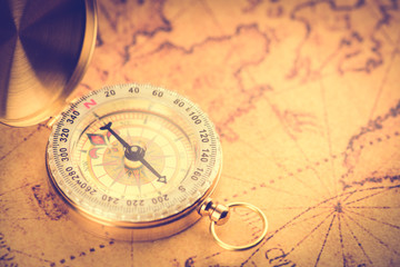 Fototapeta na wymiar Old gold vintage compass on vintage map:Heading south