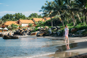 Happy girl walking along tropical beach