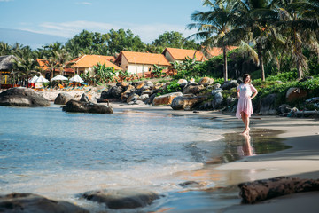 Happy girl walking along tropical beach