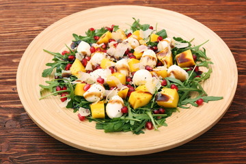 Salad with arugula, mango, cheese and pomegranate
