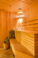 Fototapeta na wymiar Interior of a sauna. Advantage for health. Oak brooms for a steam room in traditional russian wooden bath.