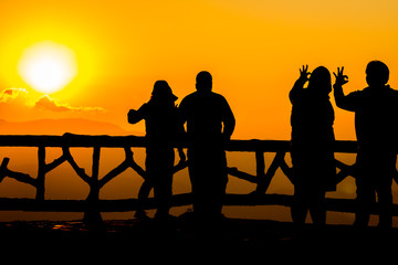 Naklejka na ściany i meble Silhouette of people having fun at sunset time
