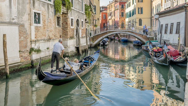 Beautiful view of a typical venetian canal, Fondamenta dei Preti, Venice, Italy, with a couple on a gondola, taking pictures and making video