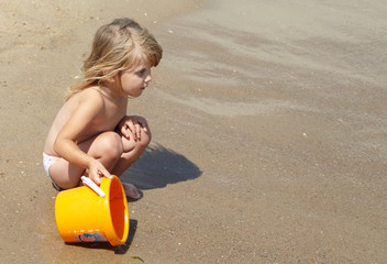 Little girl plays in the sea