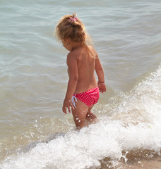 Little girl plays in the sea