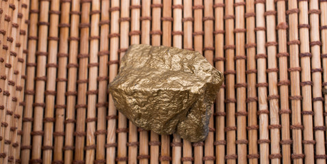 little gold color stone on straw background