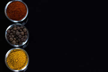 bowls of various dip sauces on black background, top view