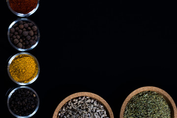 bowls of various dip sauces on black background, top view