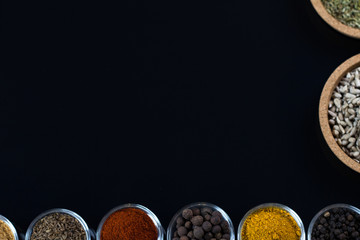 bowls of various dip sauces on black background, top view