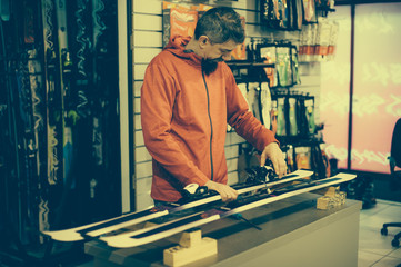 Ski repair shop worker adjust the bindings