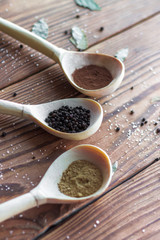 Various spices on wooden spoons
