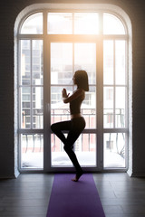 Fototapeta na wymiar Young woman in white doing yoga pose