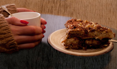 girl hand with cup of coffee and broun cake, vintage background
