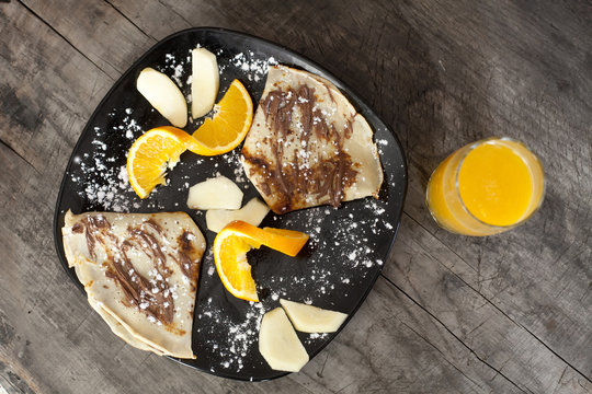 breakfast from pankakes and orange juice, vintage wooden background