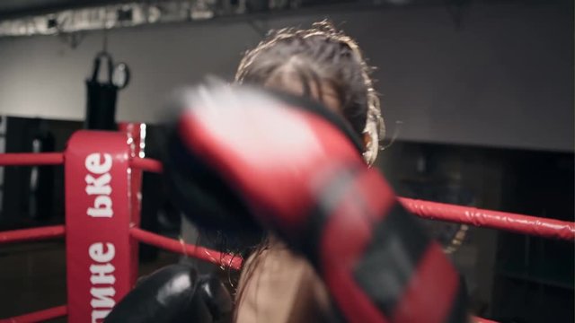 Fighter woman fist close up - boxer strikes into the side of the camcorder. Spectator video boxing