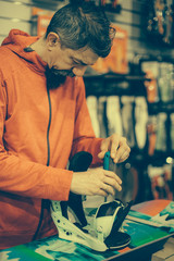 Snowboard repair shop worker adjust the bindings
