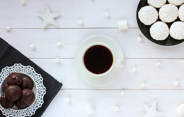 Composition with marshmallows, black coffee on white wooden background. Flat lay, top view