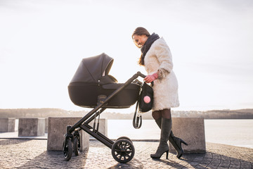 young mother walking with baby, good weather for walking, healthy lifestyle