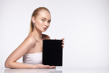 Blonde girl holds the tablet