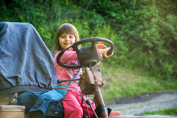 Girls pretending to drive a tractor on a sunny farm