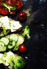 Bruschetta with tomatoes, cucumbers, cheese and lettuce, top view