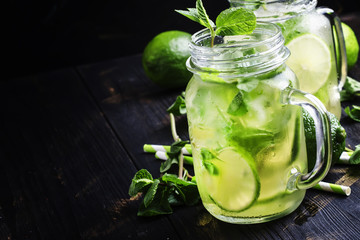 Green tea with mint and ice, black background, selective focus