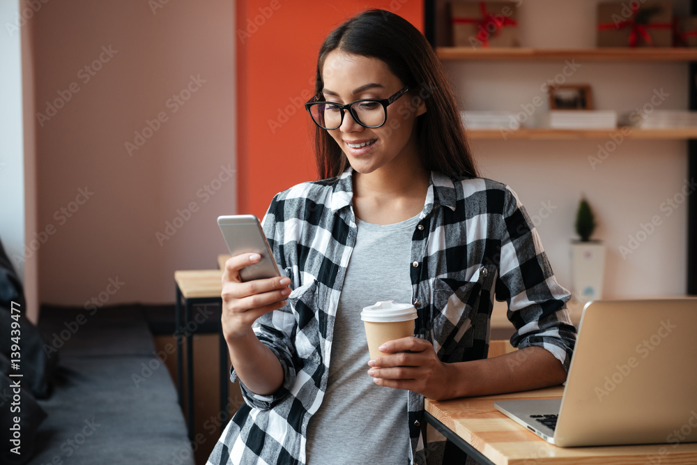 Sticker Caucasian lady chatting by phone indoors while using laptop