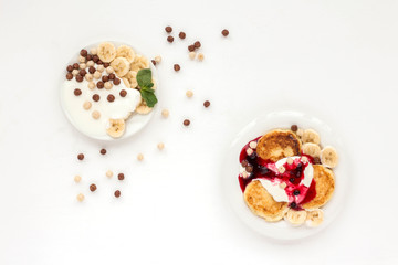 Dessert with yogurt, muesli, banana, pancake and berries on white background. Flat lay