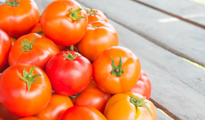 Ripe fresh red tomatoes on wooden table background.