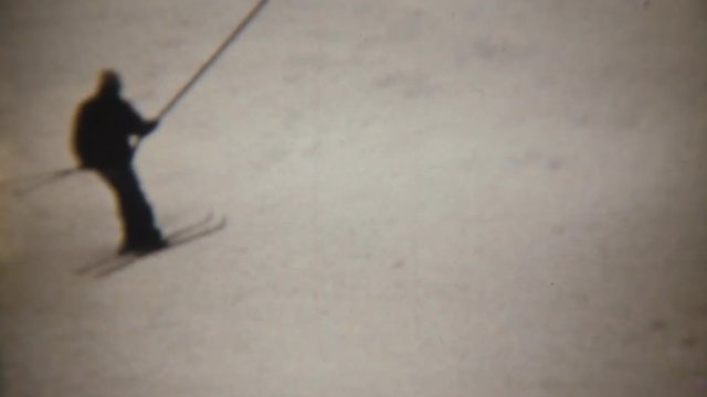 Skiers taking a skilift. Super 8 mm film vintage shot.
