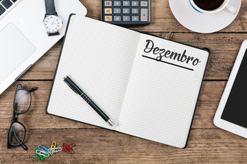 Dezembro (Portuguese December) month name on paper note pad at office desk