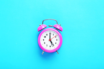 Pink alarm clock on the mint background