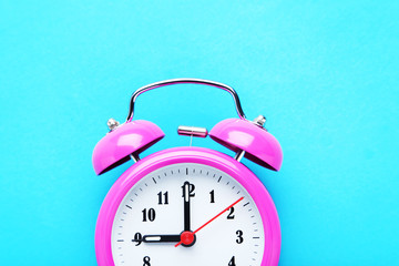 Pink alarm clock on the mint background