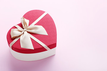 Heart gift box with ribbon on pink background