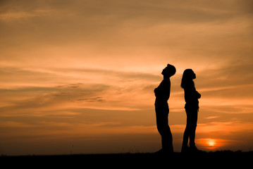 Silhouette of couples who are quarreling (standing back to back),anger and have something problems...