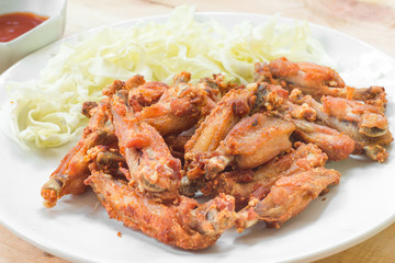 Chicken wings in plate with tomato sauce.