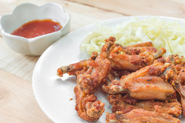 Chicken wings in plate with tomato sauce.