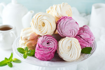 Homemade marshmallows on a light background. Russian currant and mango zephyr. Selective focus.