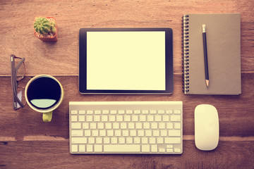 mockup tablet similar to ipad style on wood desk white display.keyboard and office stuff, workplace, top view